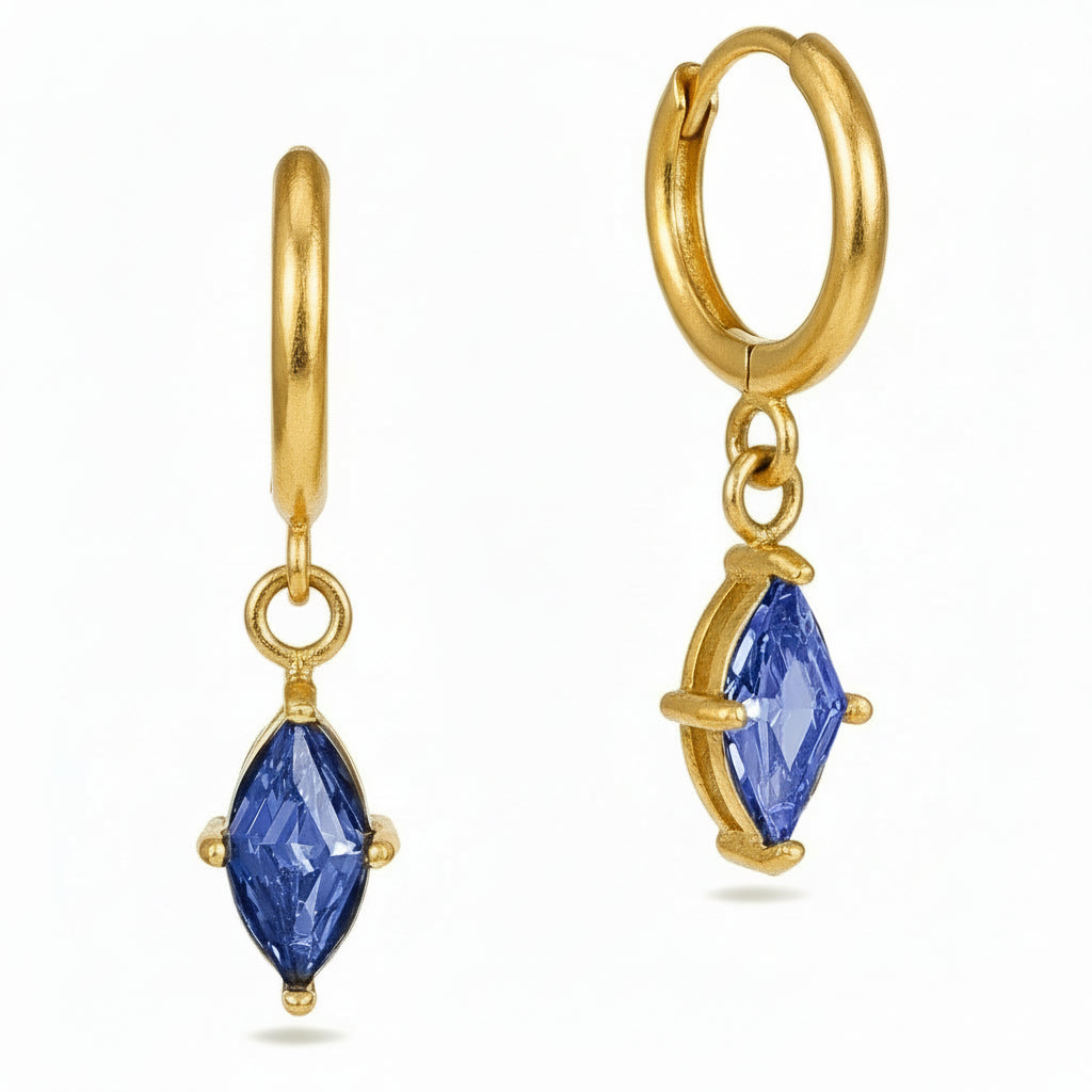 Gold hoop earrings with blue gemstones on a white background